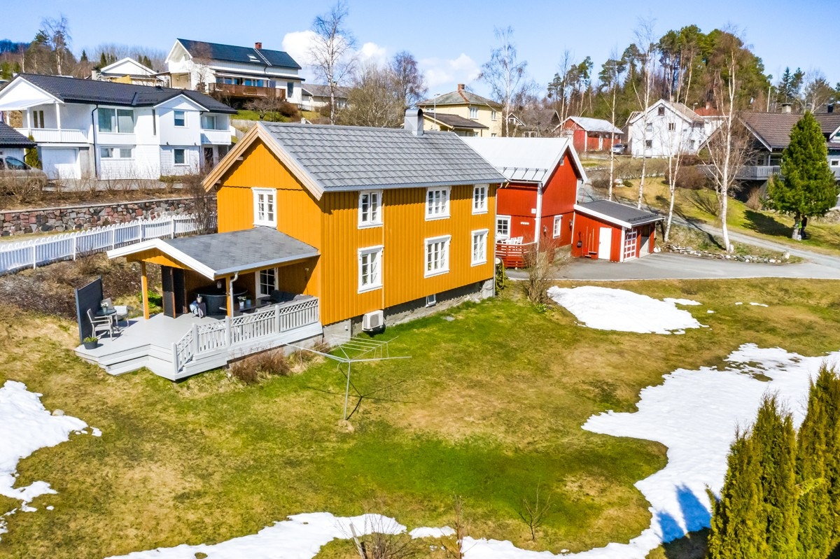 Foran huset er det god boltreplass på en gressplen blant trær, prydbusker, frukttrær og bærbusker. Galleribilde