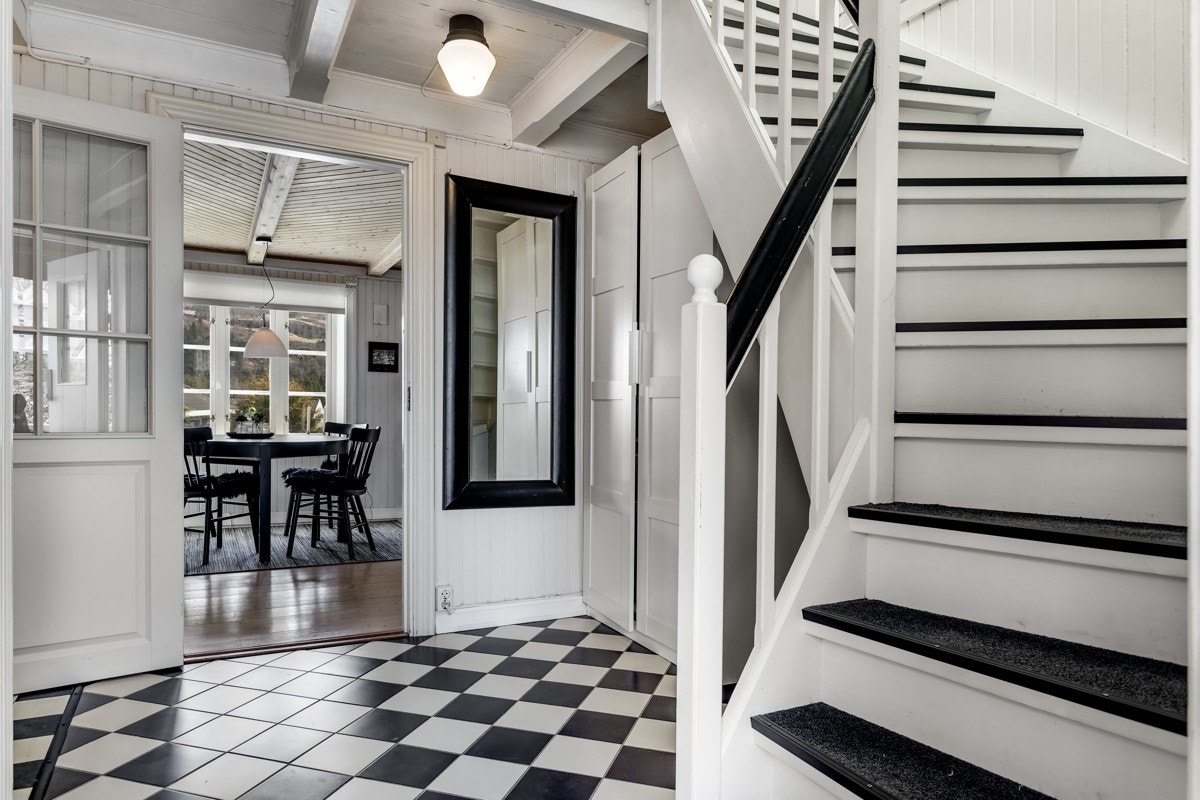 Under trappen har entreen et nyere garderobeskap og det er glassdør inn til spisestuen. Galleribilde