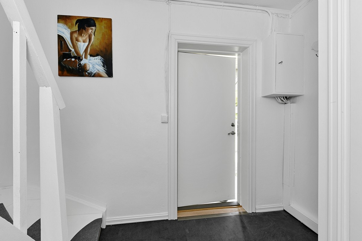 Entreen gir et vennlig førsteinntrykk, og har mørk flislaminat på gulv og glatte, lysmalte vegger. Galleribilde