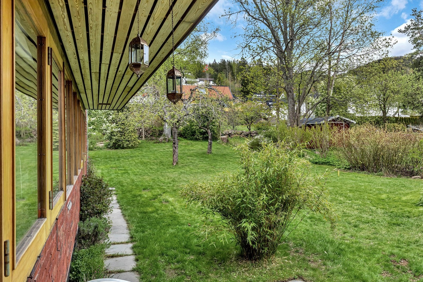Svært barnevennlig, flat og flott hage. Busker og trær rammer inn denne flotte uteplassen Galleribilde