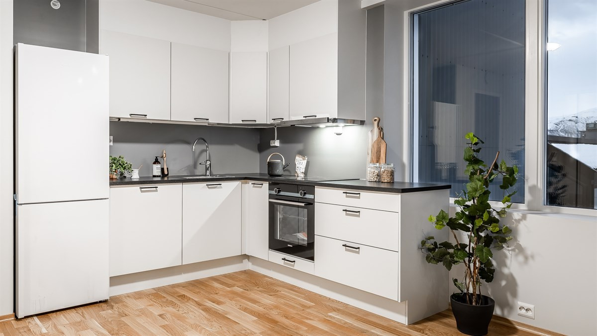 Moderne kjøkken med integrert komfyr og oppvaskmaskin.