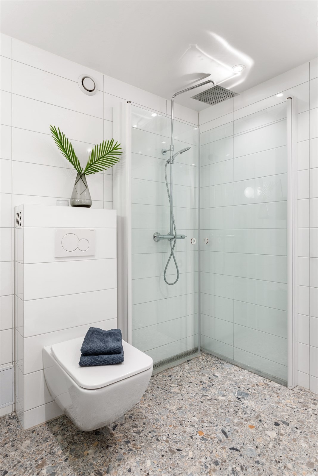 Dusjhjørne med innfellbare dusjdører og regnfallsdusj. Vegghengt wc fra Villeroy og Bosch. Galleribilde