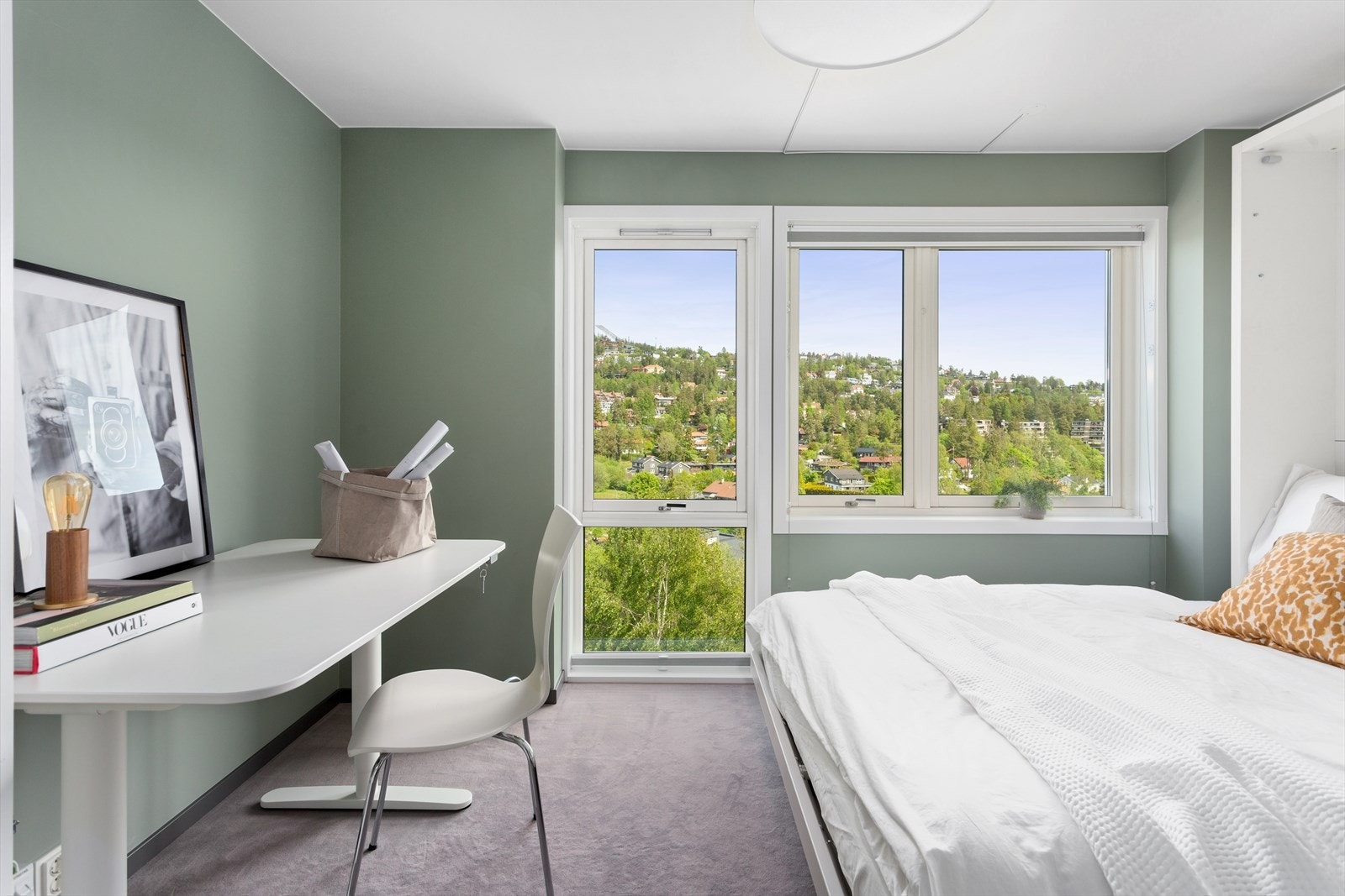 Romslig og innbydende soverom (1) med teppelagt gulv for komfort og pene slette veggflater. Store vinduer som gir mye lys og utsikt mot Holmenkollåsen. Galleribilde