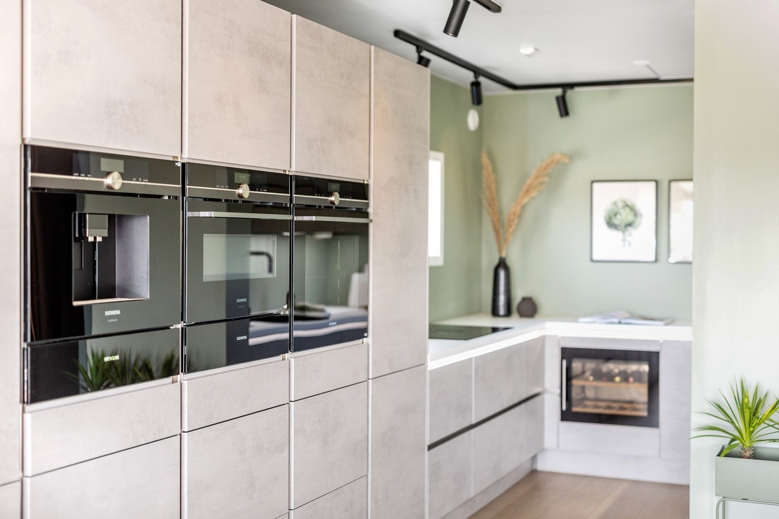 Rene linjer, moderne fronter og benkeplater samt stilfulle detaljer. Integrerte hvitevarer og vinskap. Galleribilde