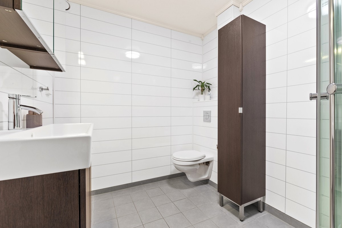 Badet har varmekabler, høyskap, gulvståående servantskap og dusjkabinett m.m. Galleribilde