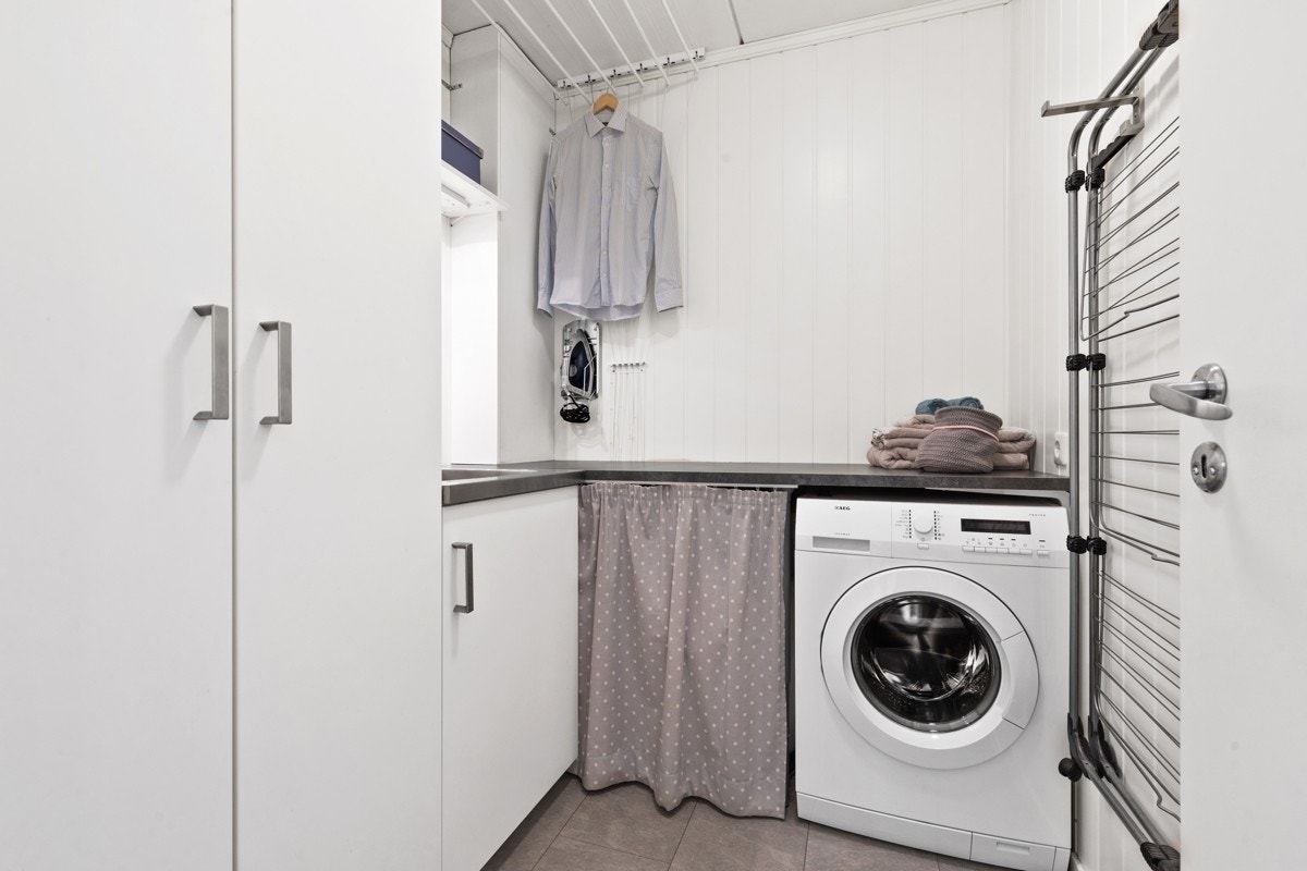 Leiligheten har et flott og praktisk vaskerom med god oppbevaringsplass og benkeplate for bretting av tøy Galleribilde