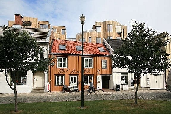 Leiligheten ligger i tårnet som ligger bak det okerfargede huset. Galleribilde