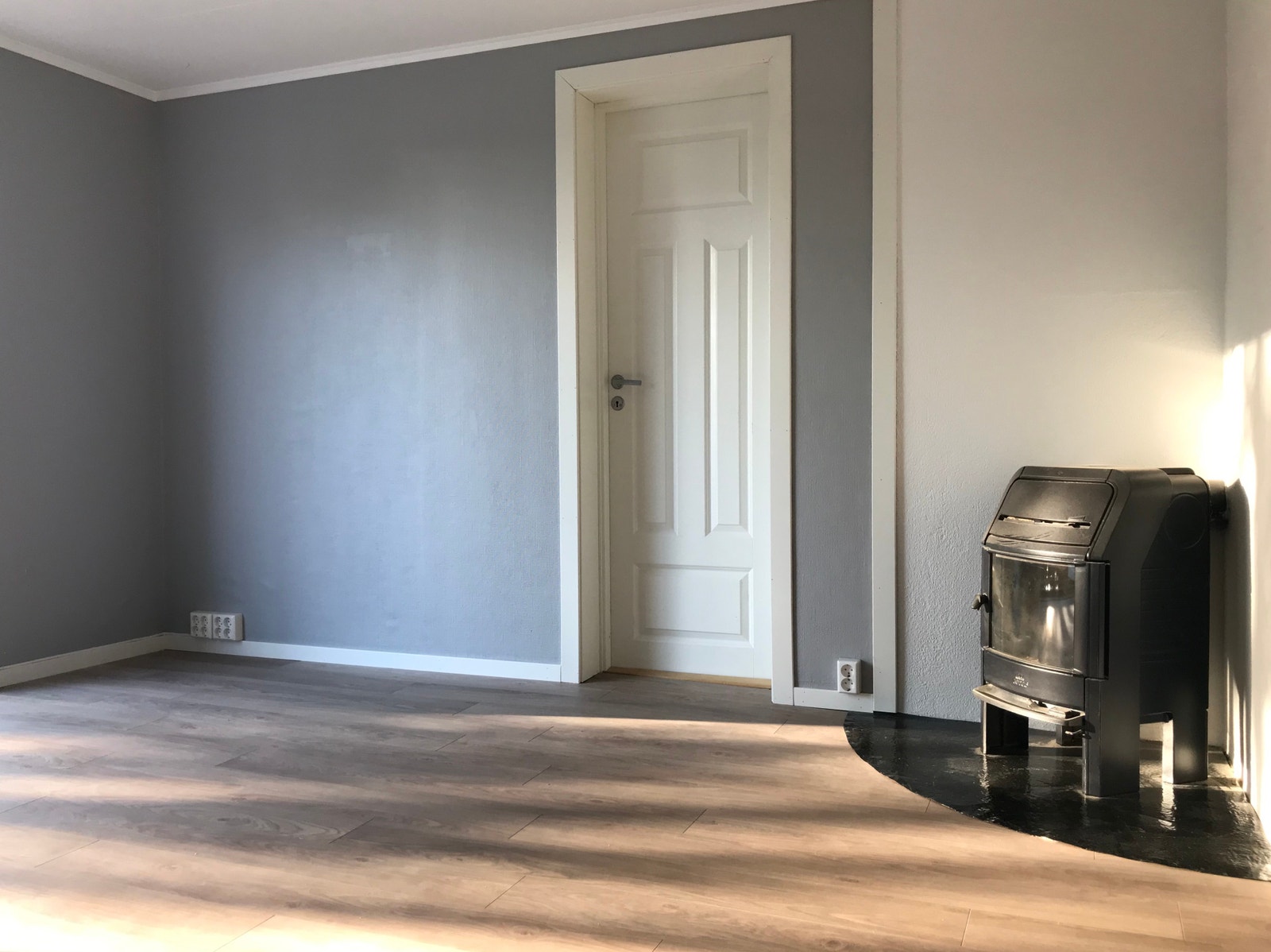 Koselig stue med peis og inngang til et lyst og romslig soverom Galleribilde