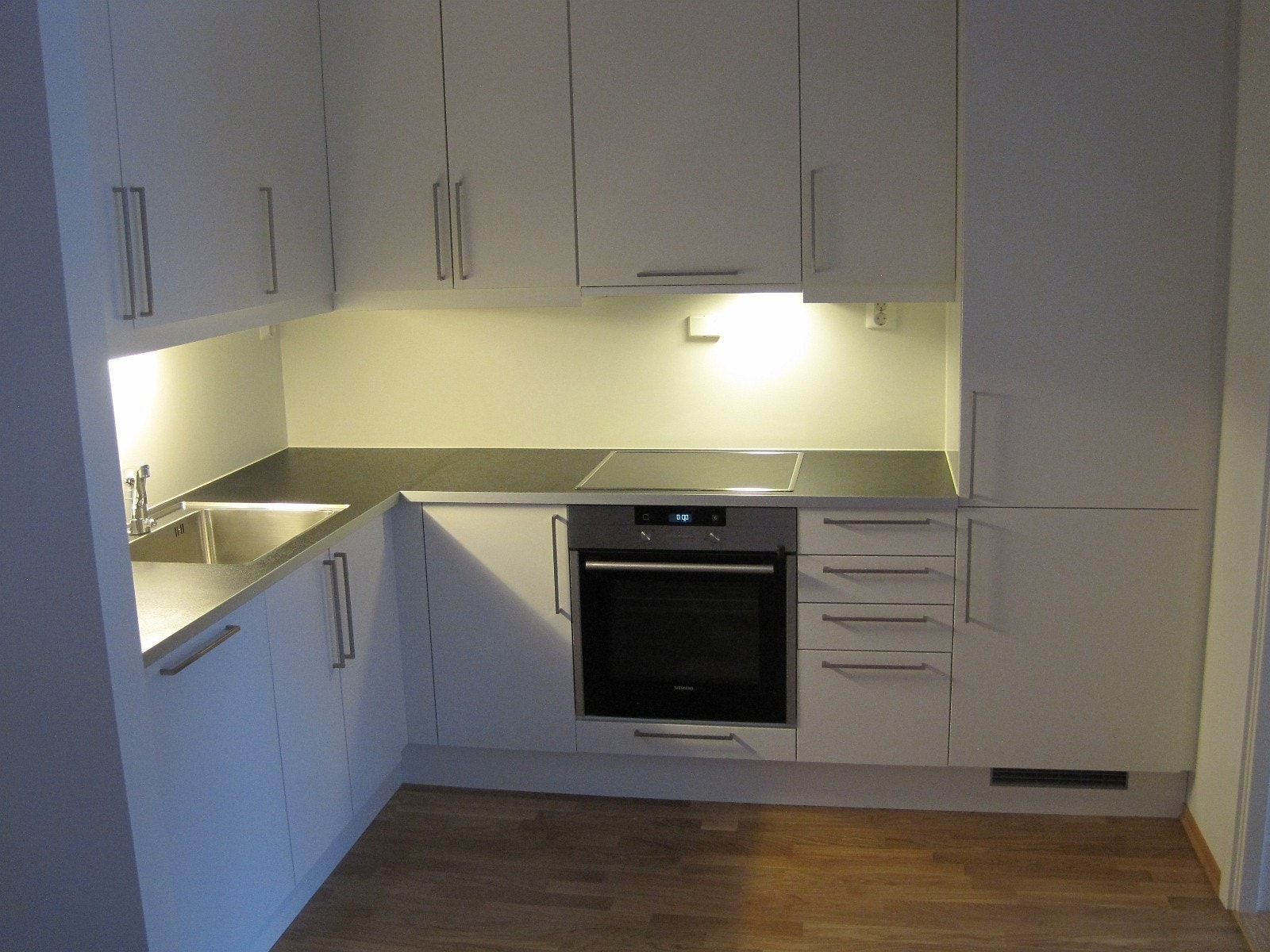 Kjøkkenet har integrert kombiskap og oppvaskmaskin. Komfyren har barnesikring. Underlimt vask, aluminiumskantet benkeplate og demping i skuffer. Galleribilde