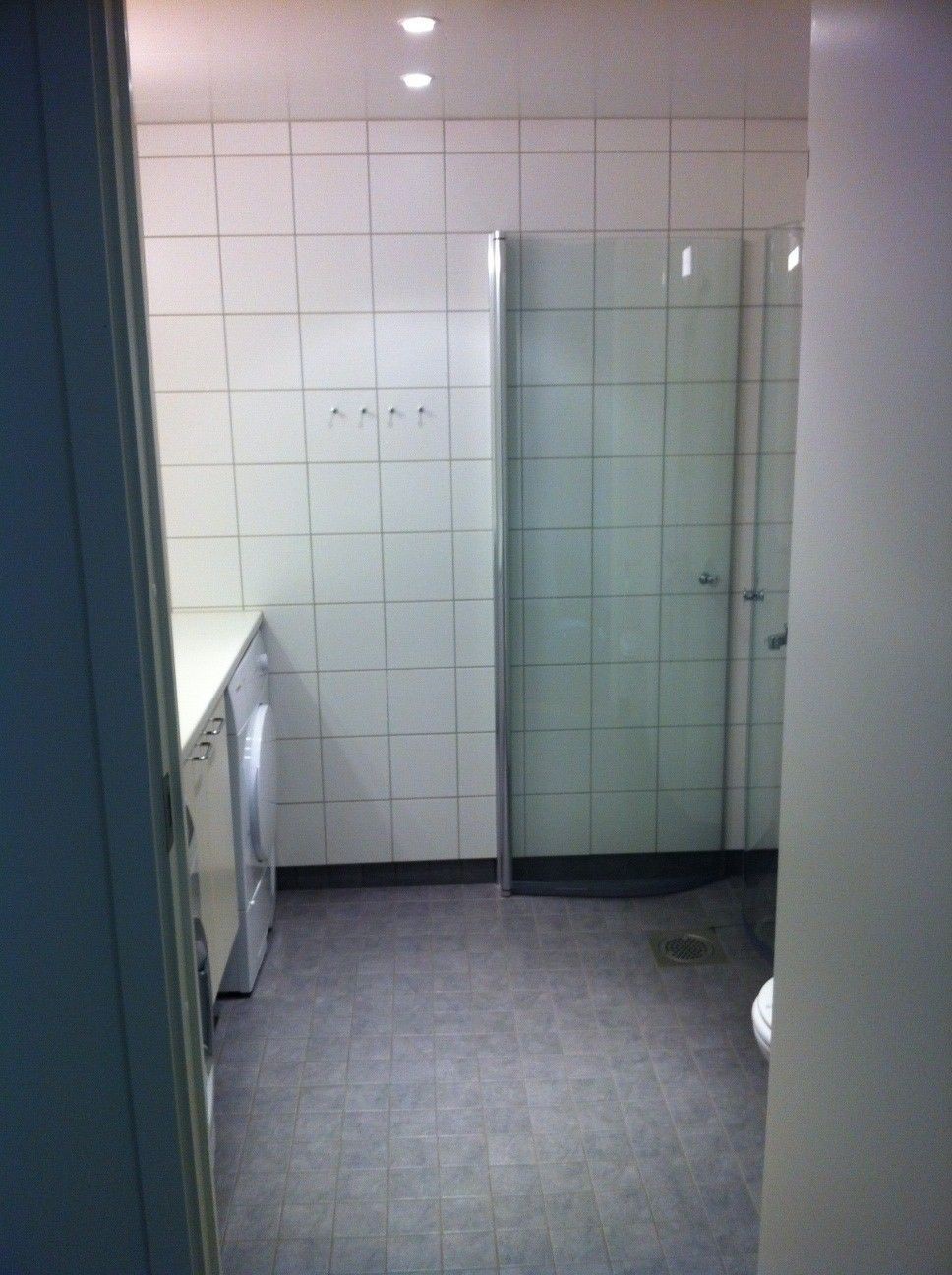 Romslig bad med veggmontert toalett og bevegelige dusjdører Galleribilde