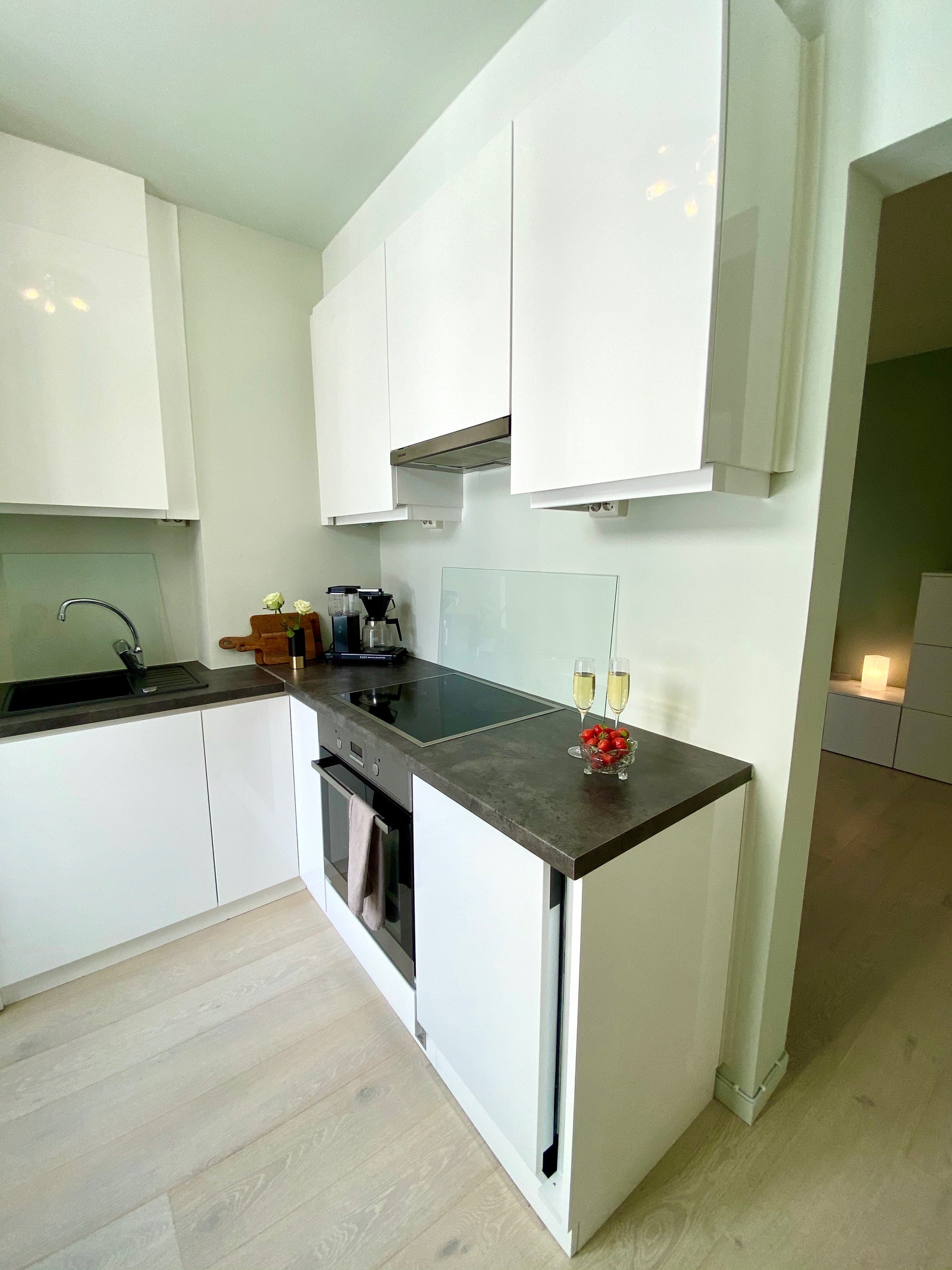 Praktisk kjøkken med oppvaskmaskin, vaskemaskin, induksjonsovn og mikrobølgeovn. Galleribilde