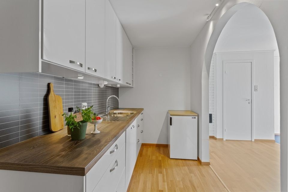Kjøkkeninnredningen er i hvit høyglans utførelse, og det er laminat benkeplate. Innredningen har integrerte hvitevarer som stekeovn, koketopp og oppvaskmaskin. Galleribilde