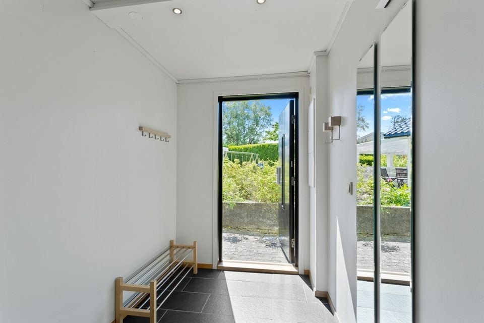 Det er egen inngang til den moderniserte leiligheten. Gangen har lyse vegger og fliser på gulvet. Fra gangen er det tilkomst til baderommet og til stuen. Galleribilde