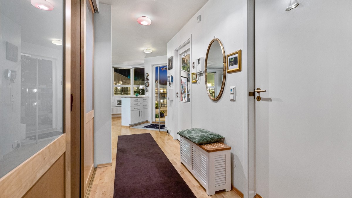 Man kommer inn i en lys gang med adkomst til et stort walk-in-closet. Galleribilde