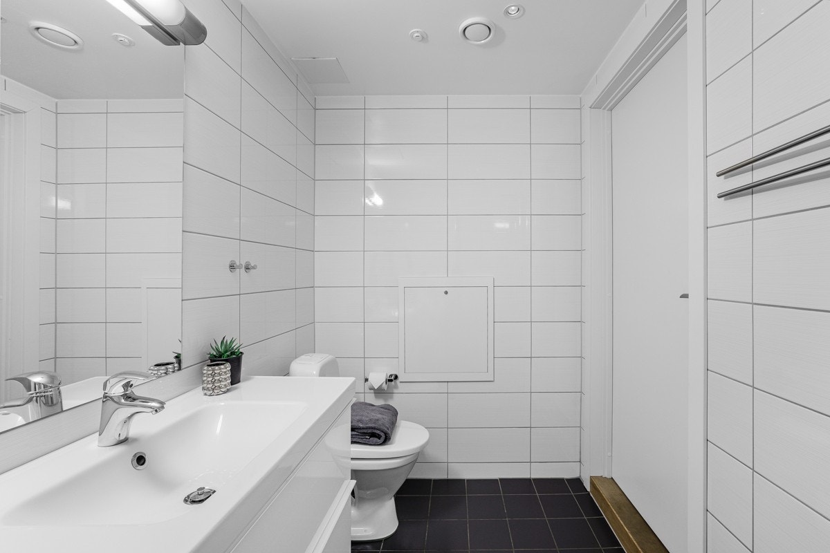 Badet er utstyrt med servant over skuffer, wc, speil m/lys og dusjnisje. Videre er det opplegg til vaskemaskin og tørketrommel. Galleribilde
