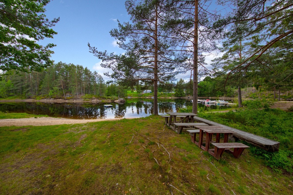 Nede ved vannkanten er det anlagt en koselig lekeplass med sittebenker og en fin sandstrand. Galleribilde