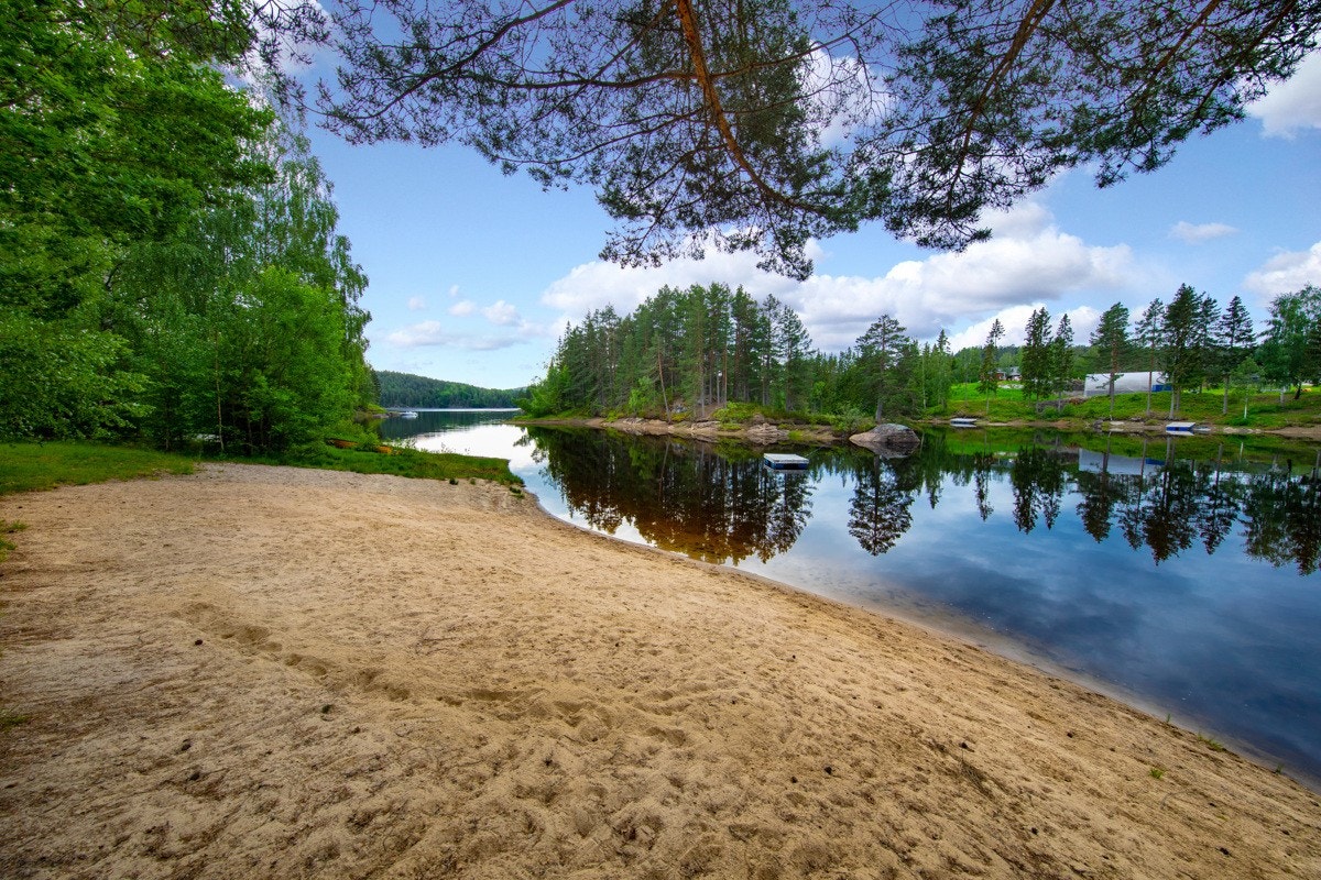 Nede ved vannkanten er det anlagt en koselig lekeplass med sittebenker og en fin sandstrand. Galleribilde