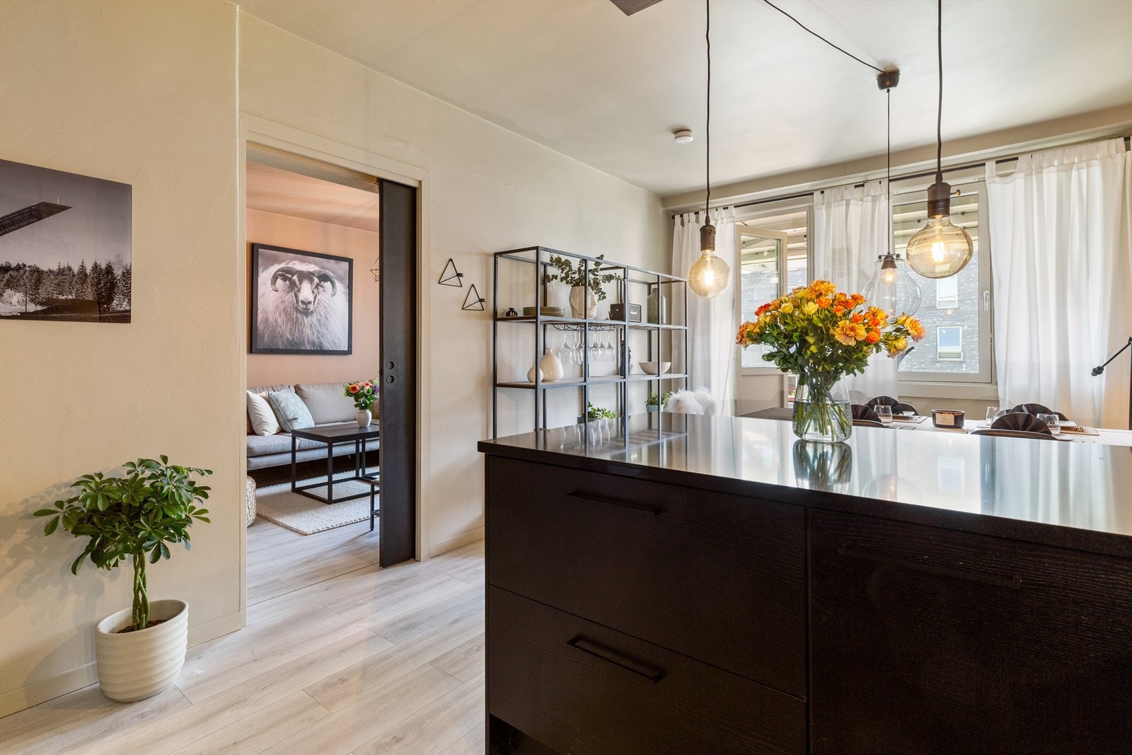 Kjøkkenhalvøy med skap/skuffer og som ligger i en åpen løsning mot stuen. Galleribilde