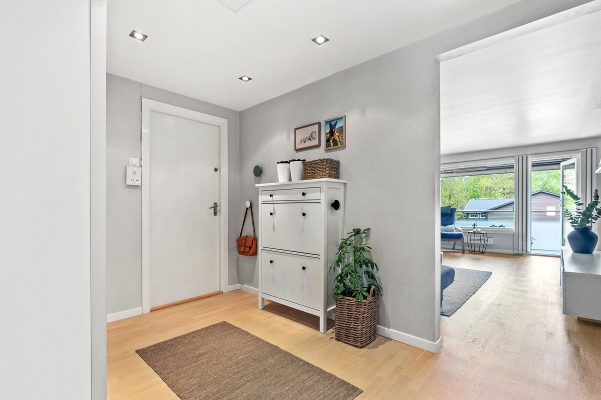Lys og fin entré som gir en varm velkomst og godt førsteinntrykk av leiligheten. Det er plass til møblement for oppbevaring av yttertøy. Galleribilde