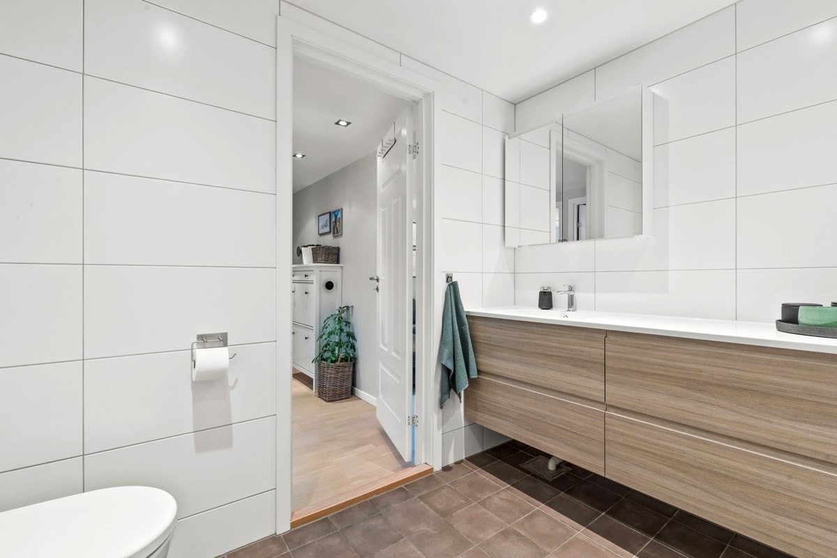 Baderommet har bl.a. behagelig gulvvarme, nedsenket himling med downlights og opplegg for vaskemaskin og tørketrommel. Galleribilde