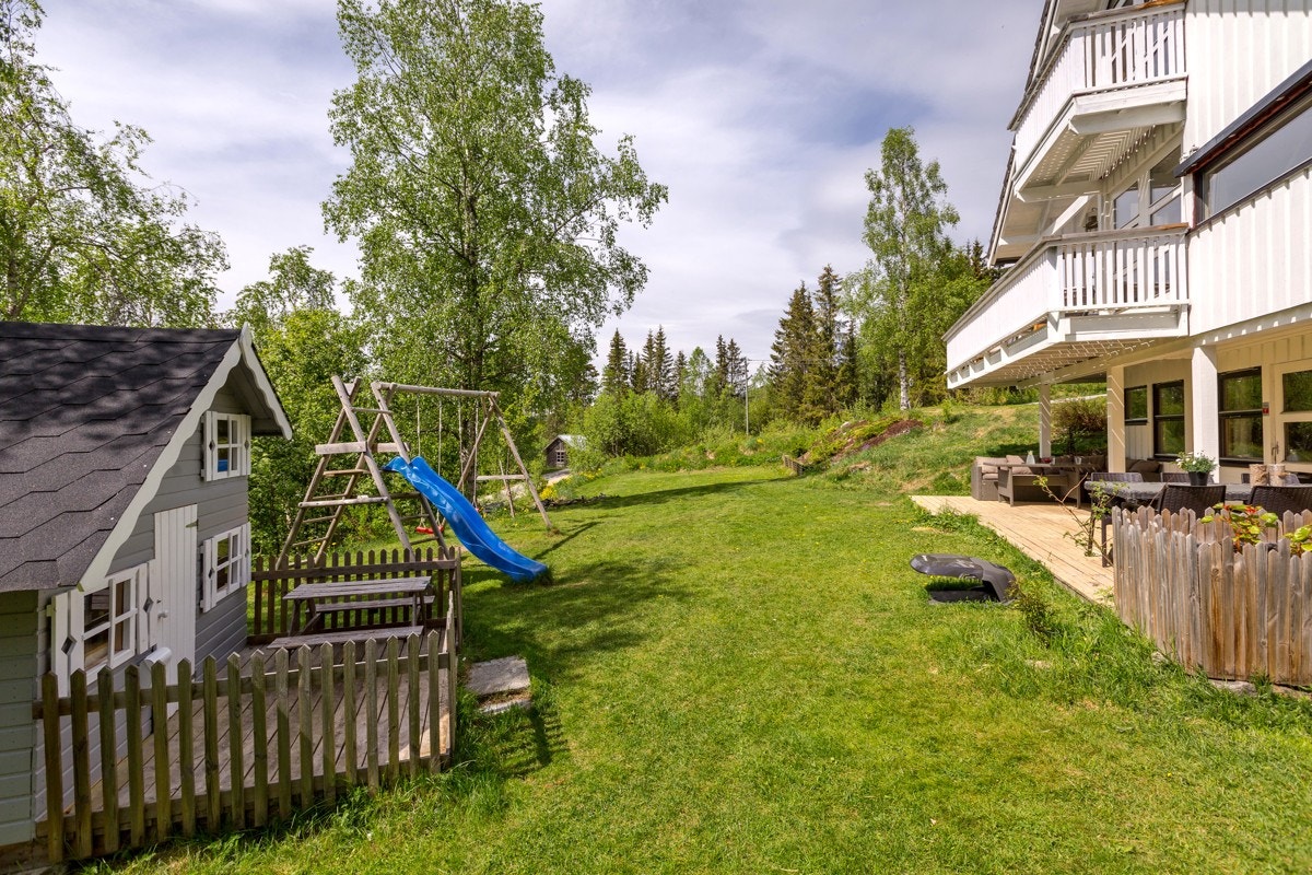 Terrassert tomt med flate partier ved inngangspartiet og på nedsiden av huset. Galleribilde