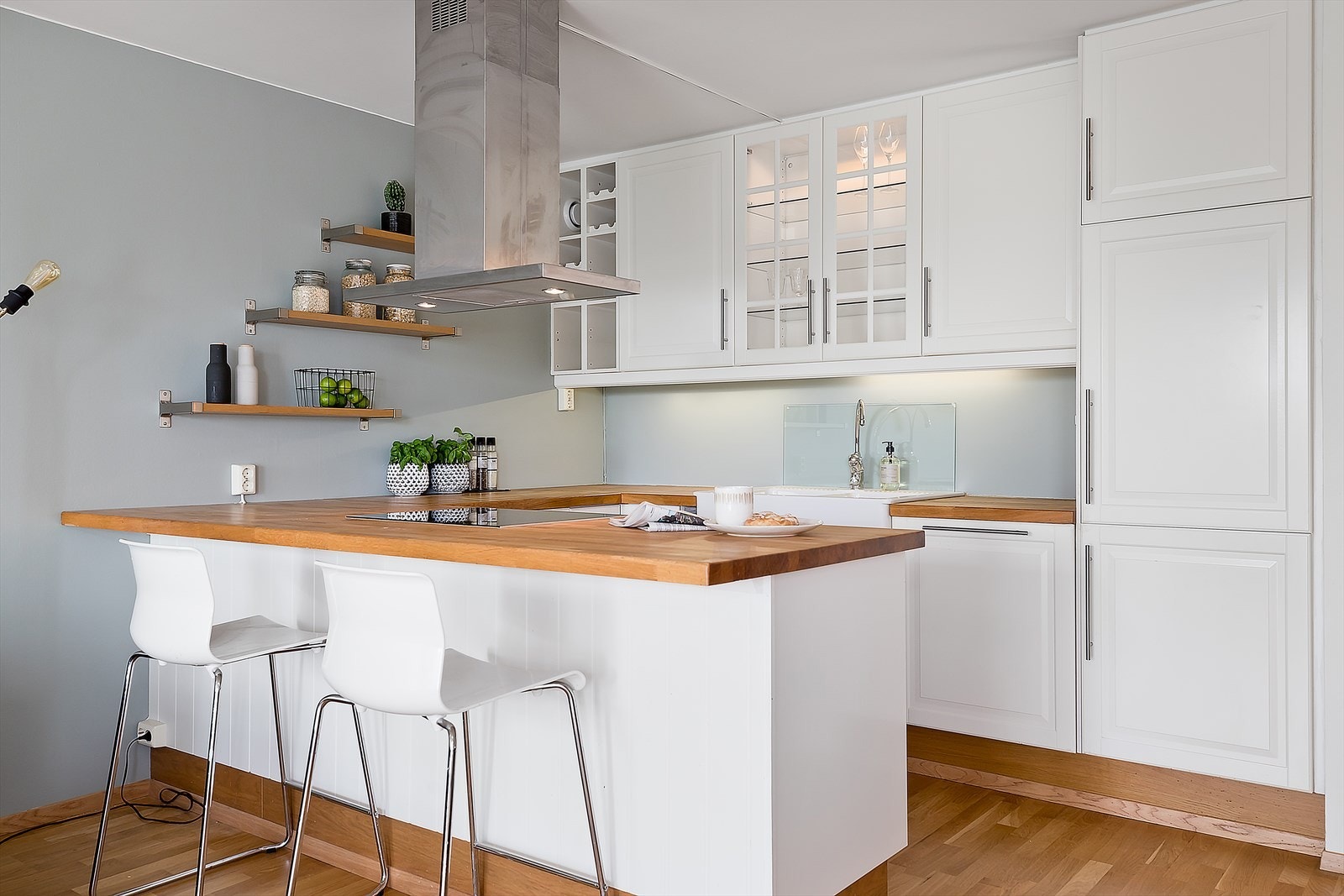 Lyst og delikat kjøkken fra 2013 med raus benkeplate av eik, backsplash av glass og en rekke moduler og overskap som gjør det enkelt å holde det ryddig. Galleribilde