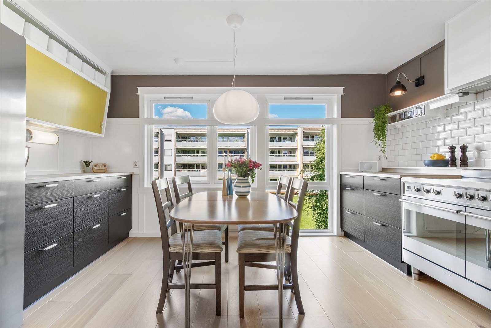 Stort separat kjøkkenrom med gulvgående vindu og plass til spisegruppe. Én-stavs parketten strekker seg fra stuen og inn på kjøkkenet og gir et helhetlig og tiltalende uttrykk. Galleribilde