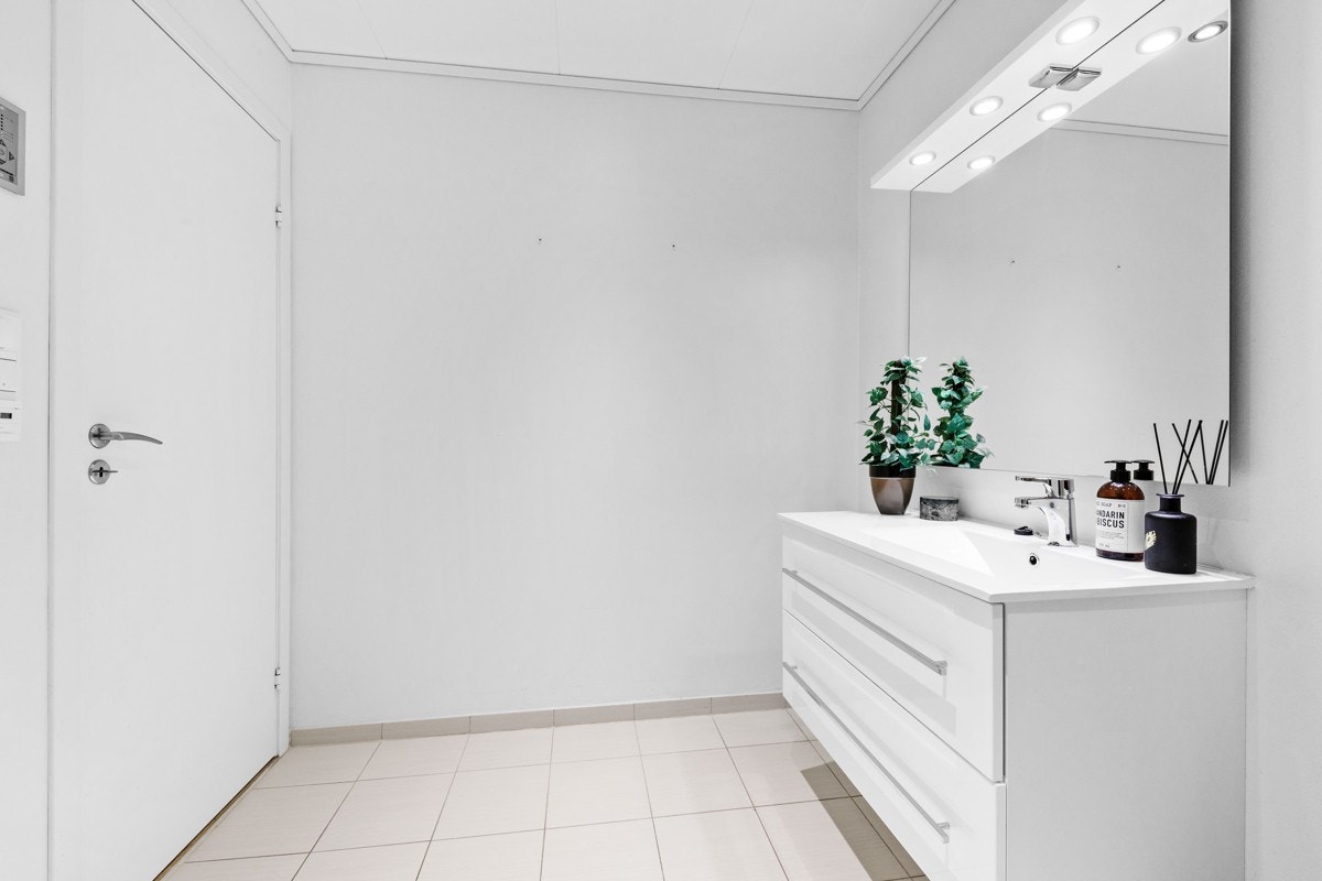 Lyst og flott bad med flislagd golv og varmekablar Galleribilde