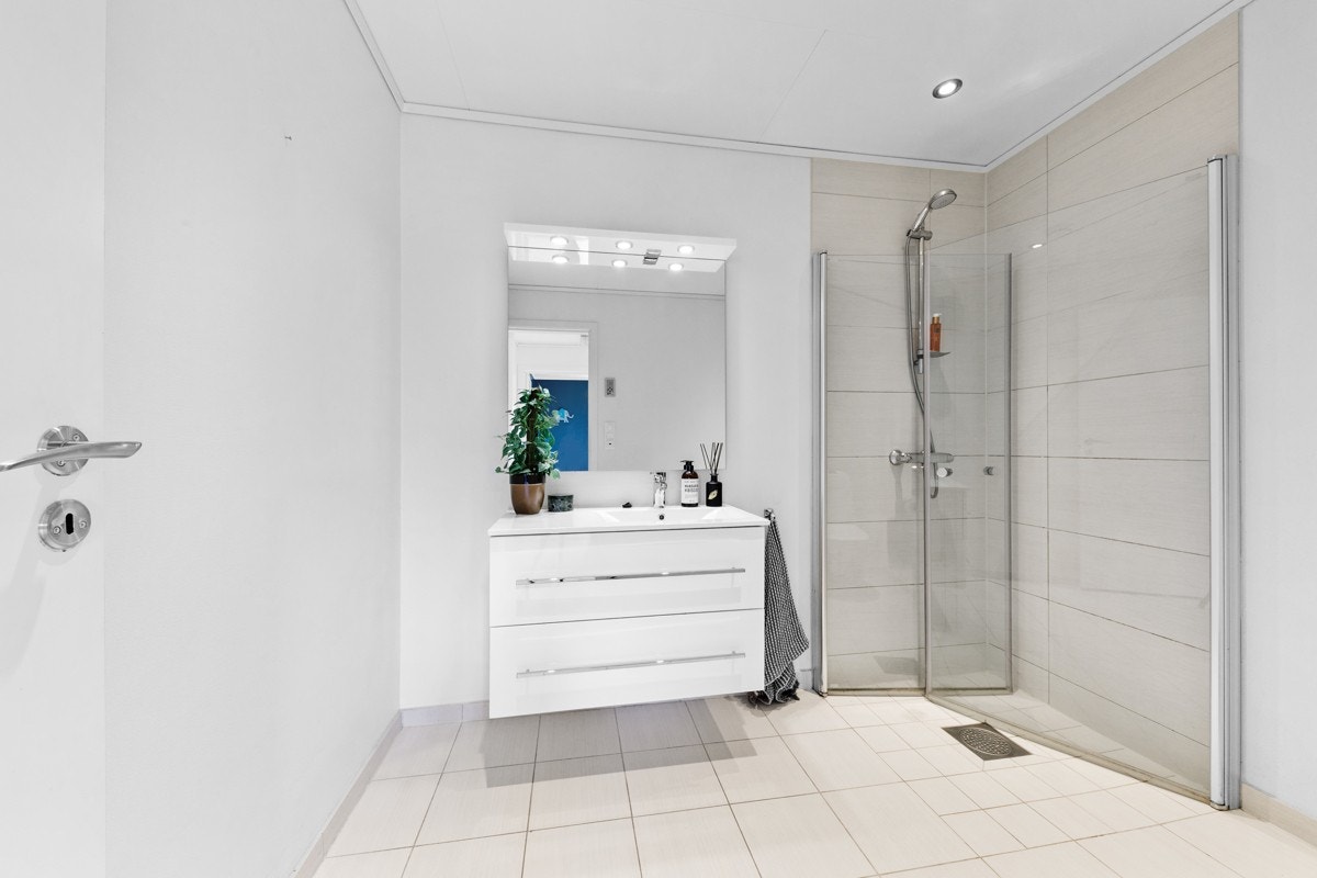 Badet har downlight i himlinga og flislagde veggar i dusjsona Galleribilde