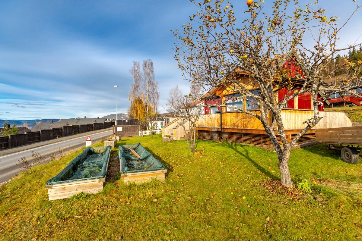 Tilnærmet flatt plenareale på nedsiden av huset Galleribilde