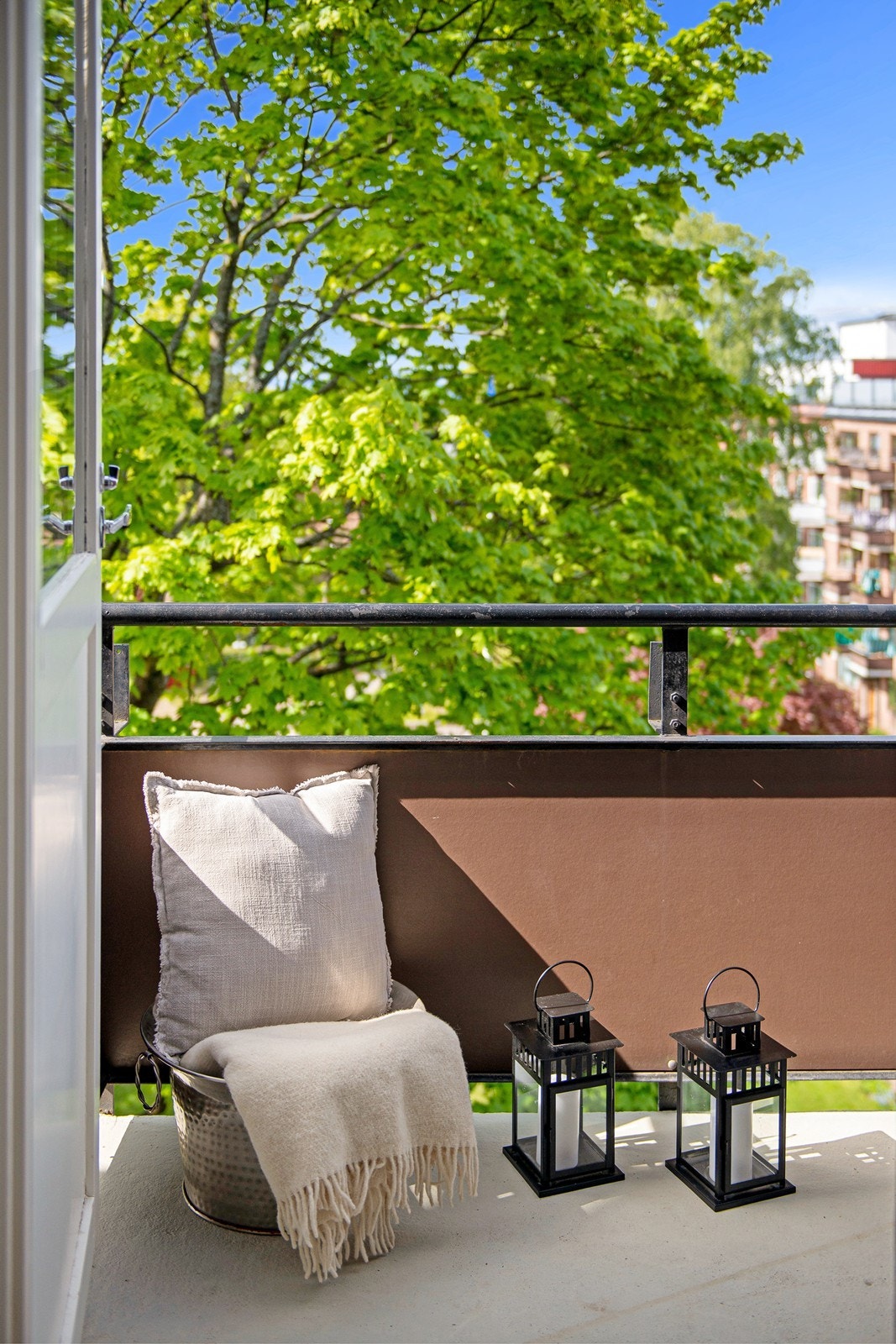 Balkongen er vendt inn mot felles hage/ parkanlegg med beplantning, gressplen og sittegrupper Galleribilde