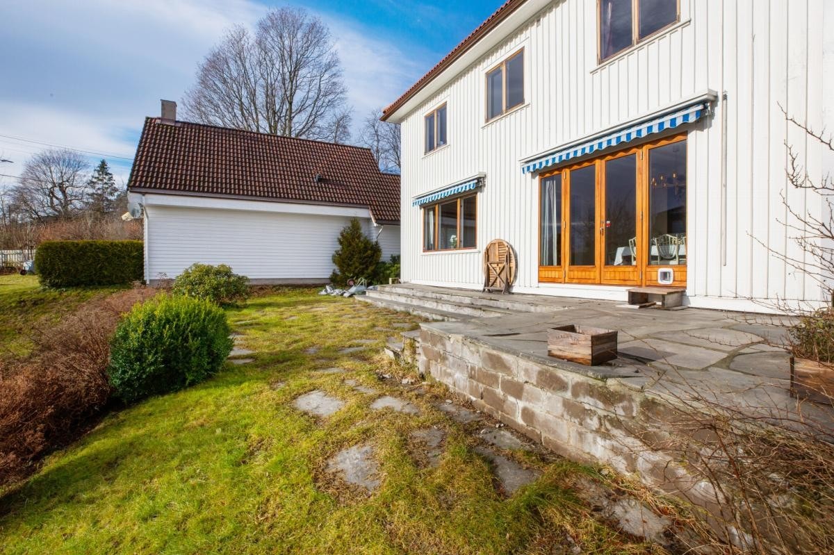 Fasade mot hagesiden. Skiferbelagt terrasse. Galleribilde