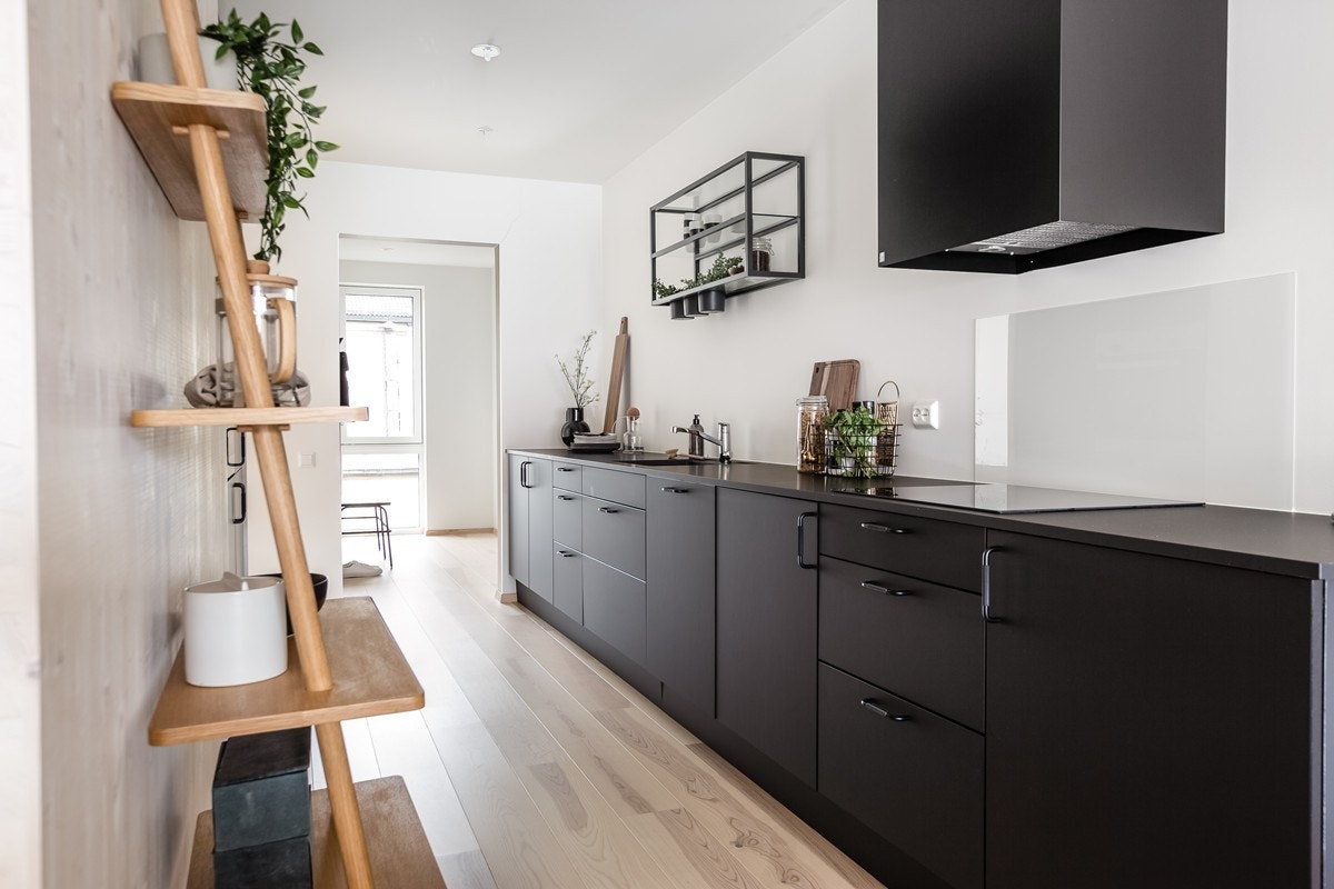 Leiligheten er levert med et lekkert, mørkt HTH-kjøkken med integrerte hvitevarer fra Siemens, laminat benkeplate og ventilator fra Røroshetta. Bildet er fra en annen leilighet. Galleribilde