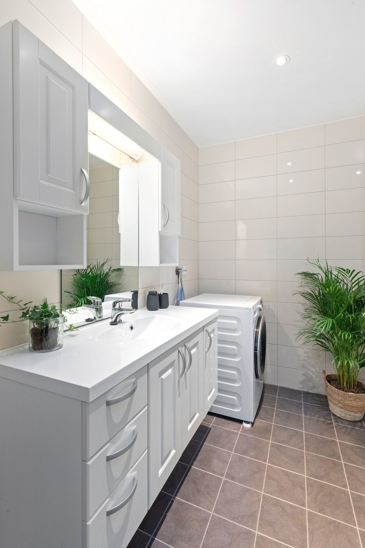 Badet har dusjhjørne, vegghengt toalett, servant med underskap/underskuffer samt overspeil. Opplegg til vaskemaskin Galleribilde