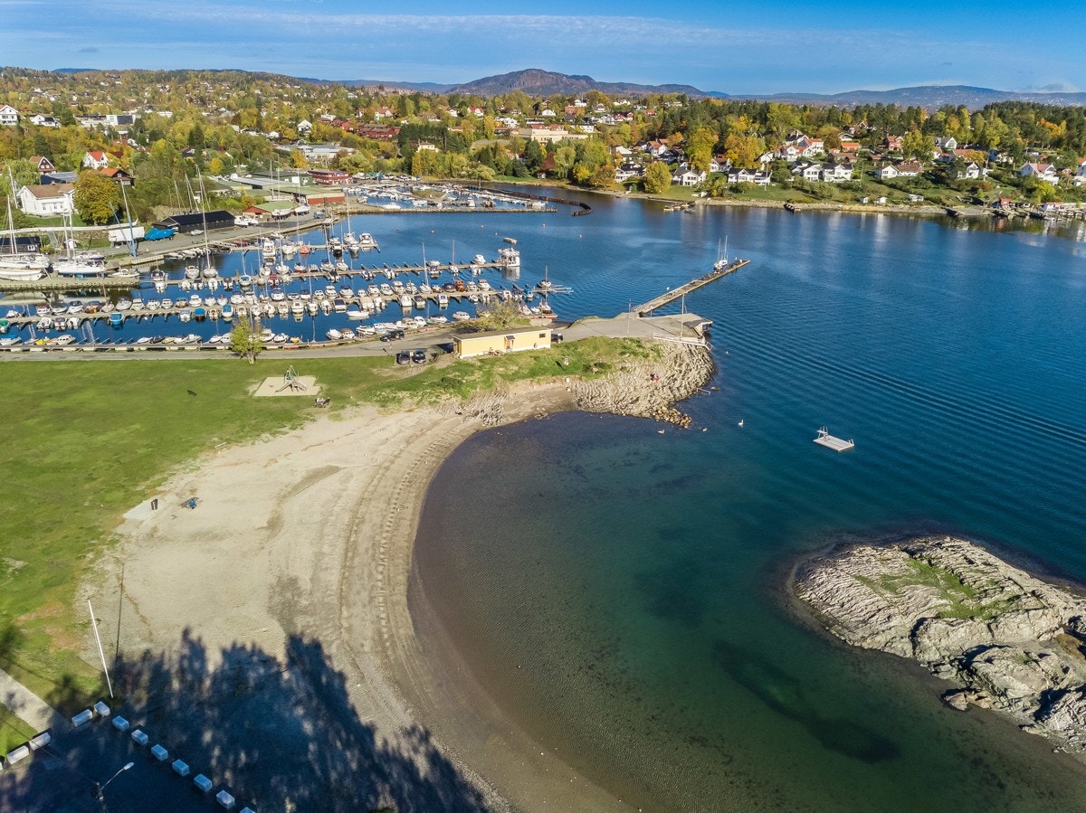 Holmenskjæret badestrand er en meget barnevennlig langgrunt strand med gresslette og flytebrygge. Galleribilde