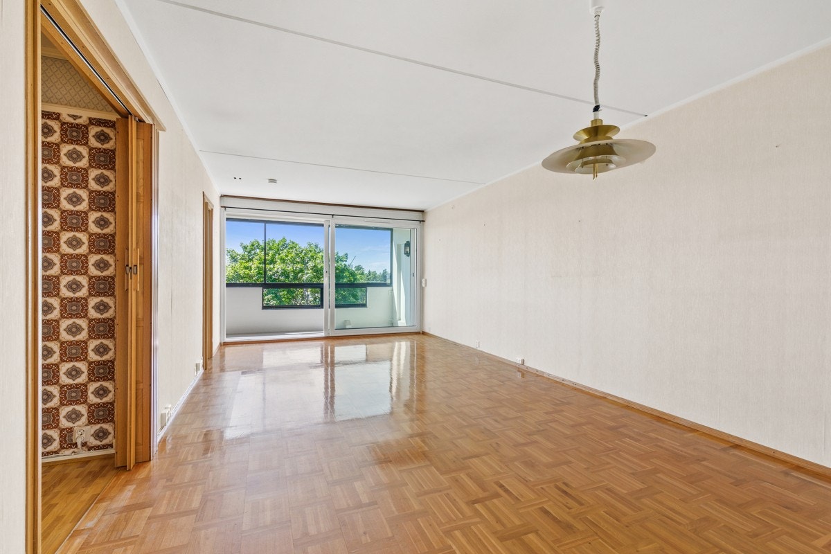 Store vindusflater mot balkongen sørger for godt med lys og gir en behagelig romfølelse Galleribilde