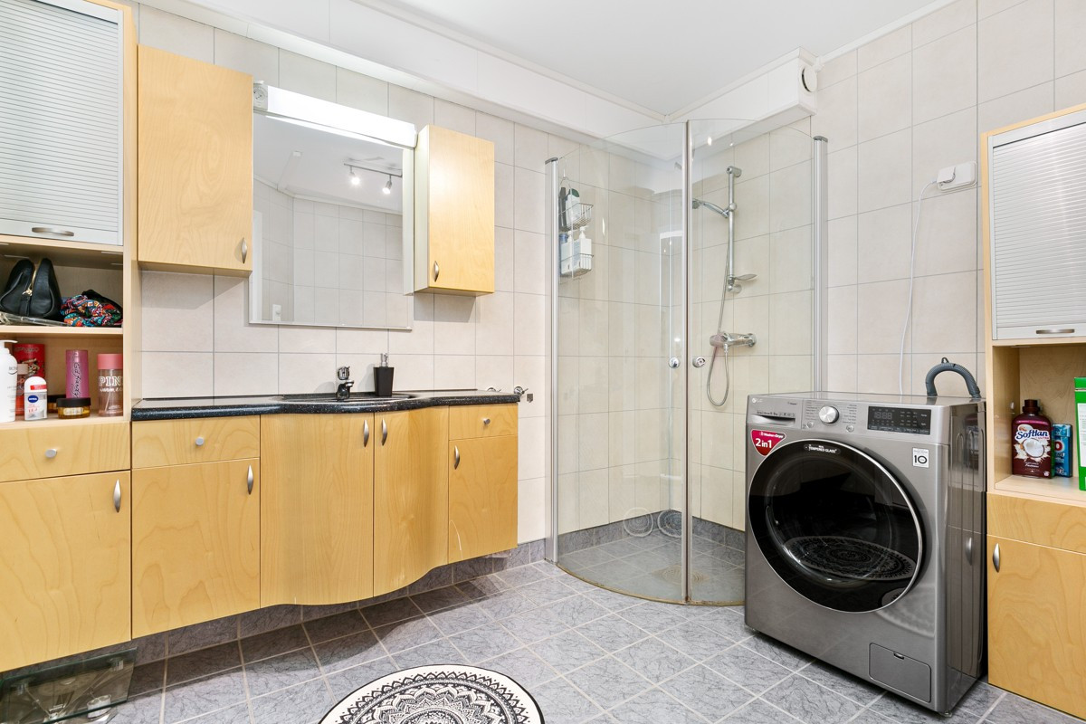 Badet er utstyrt med dusjhjørne, godt med skapplass og vegghengt toalett