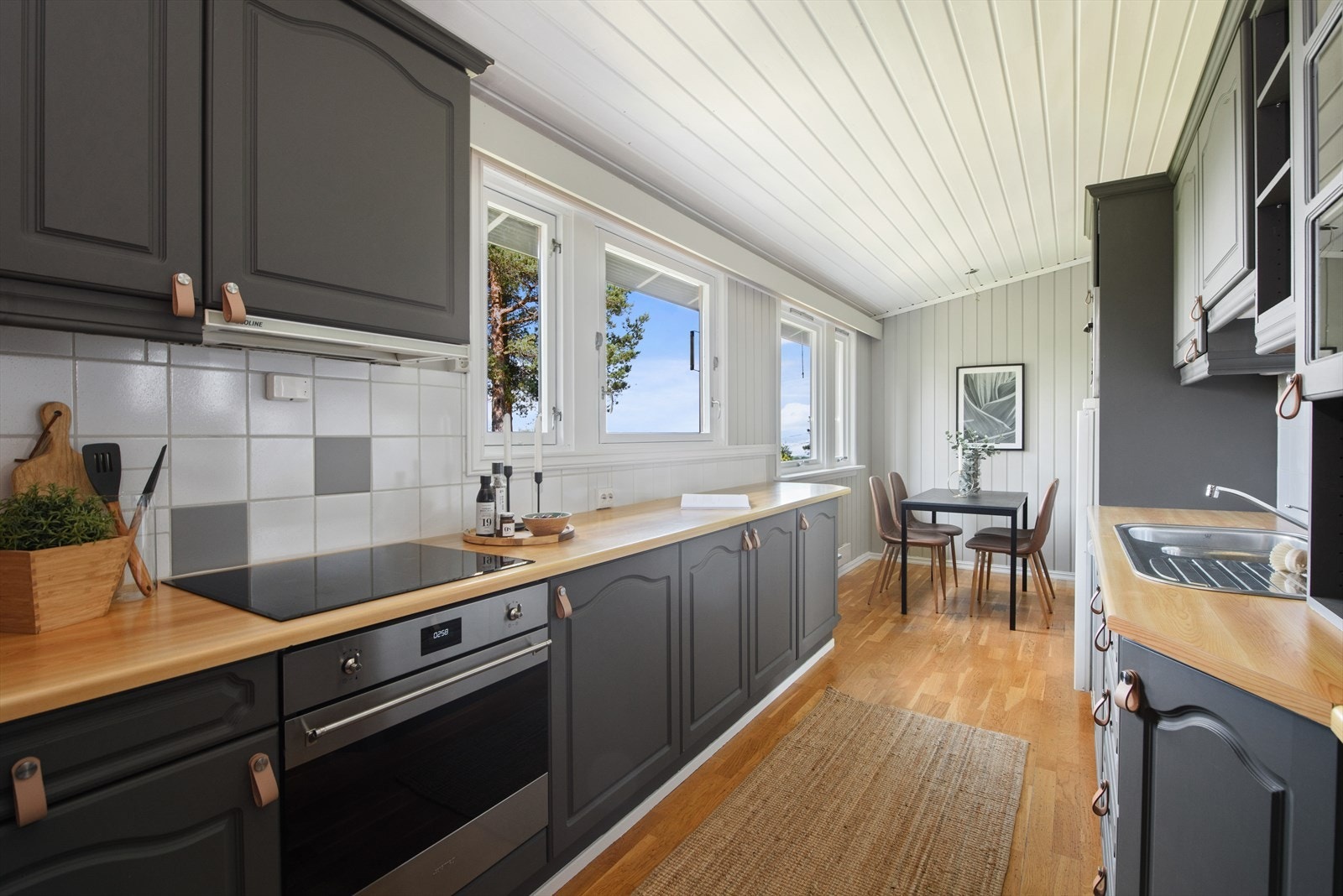 Kjøkken med spiseplass - nyere induksjon platetopp og stekeovn. Galleribilde