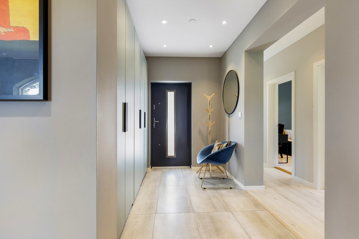 Entreen er lys og innbydende med gråmalte vegger, downlights i himling og varme i gulv. Galleribilde