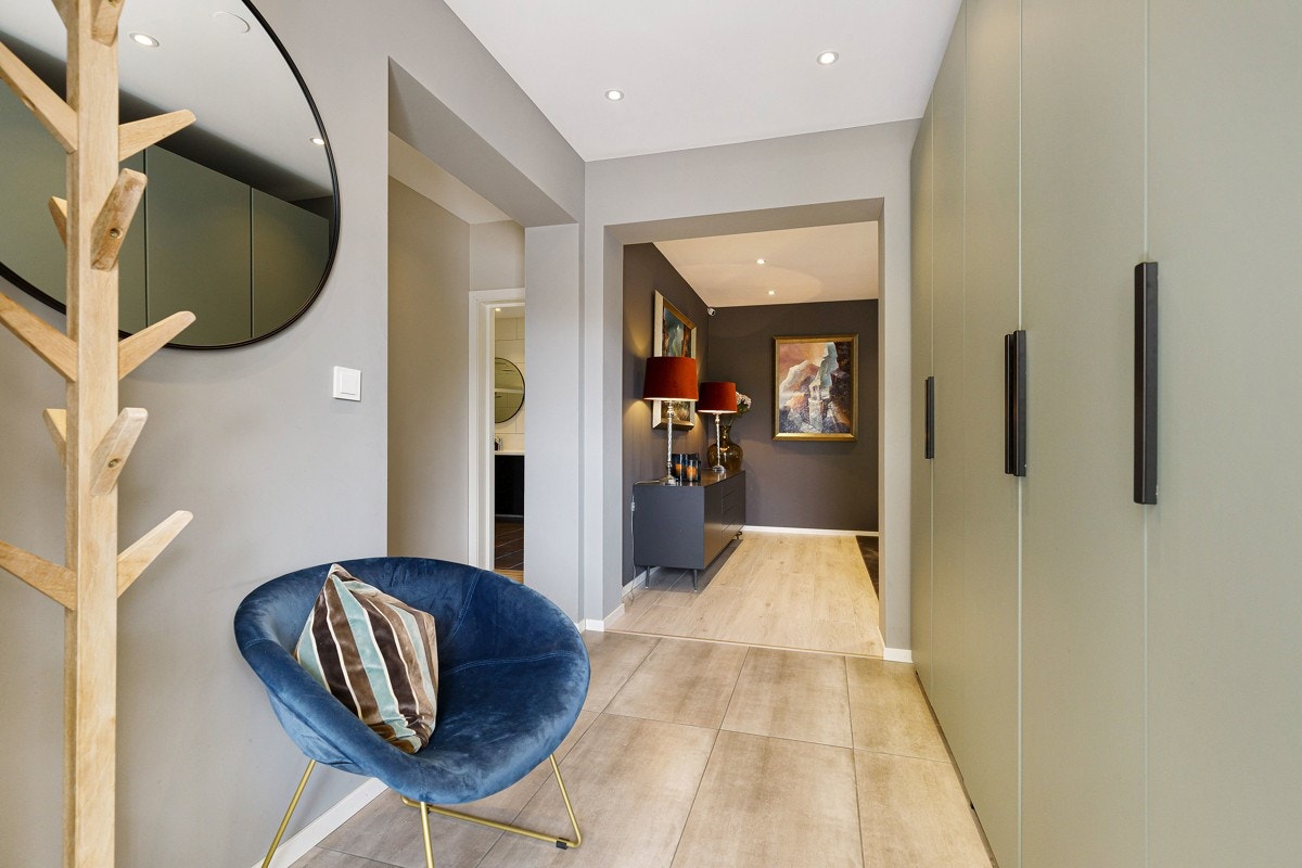 Entreen er lys og innbydende med gråmalte vegger, downlights i himling og varme i gulv. Galleribilde