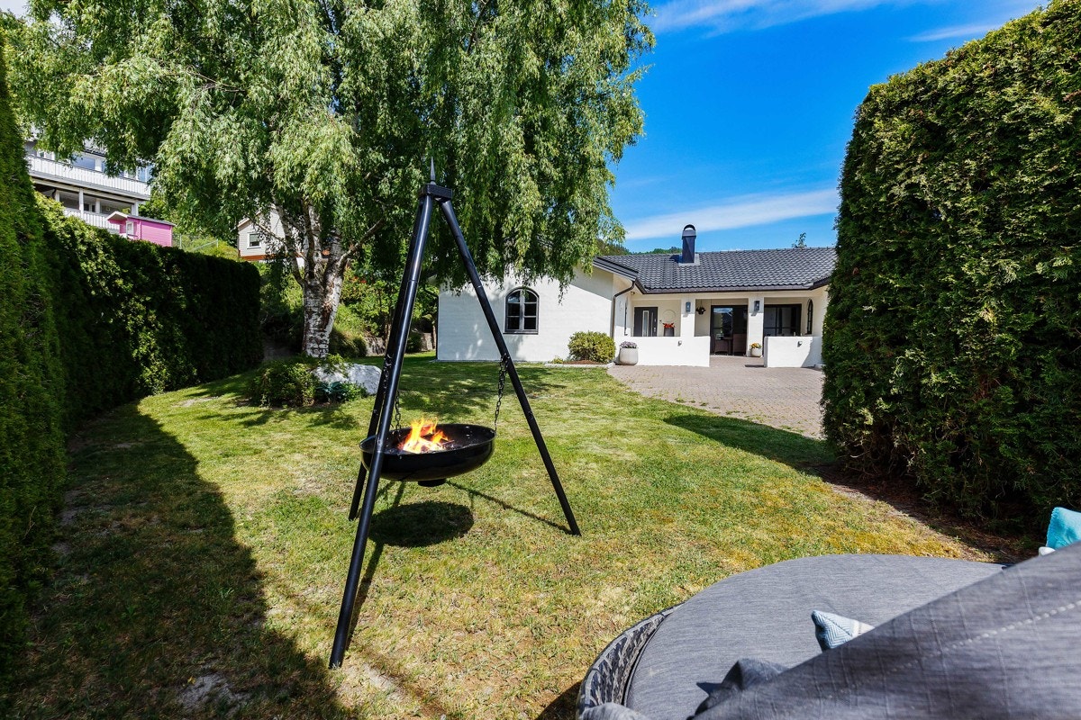 Tomten er tilnærmet flat og pent opparbeidet med gressplen. Galleribilde