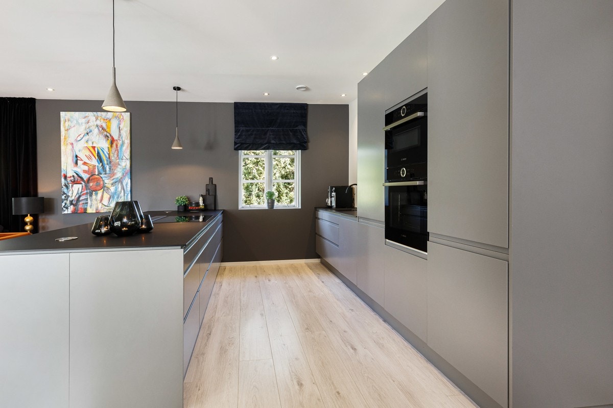 Innredning har grå fronter og en slitesterke benkeplater i sort kompositt. Galleribilde