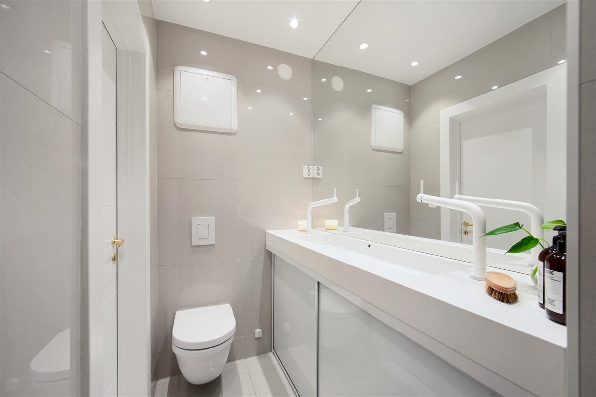 Innredningen består av en heldekkende servant med skap- og hylleløsninger Galleribilde