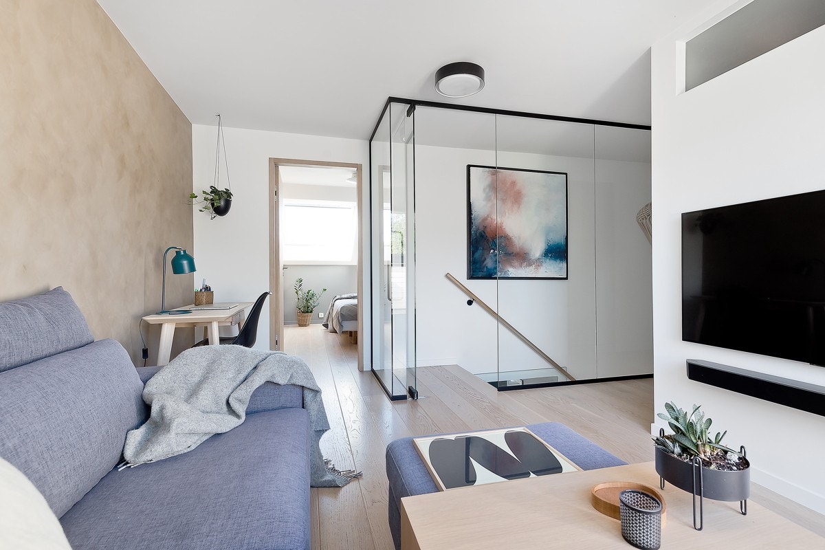 Loftsstue er adskilt fra trapperom og underliggende etasje med en elegant glassvegg fra gulv til tak. Galleribilde