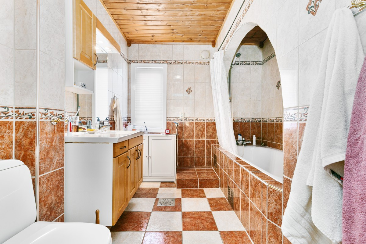 Badet i 1.etasje er komplett flislagt. Her er det innfliset badekar og gulvvarme