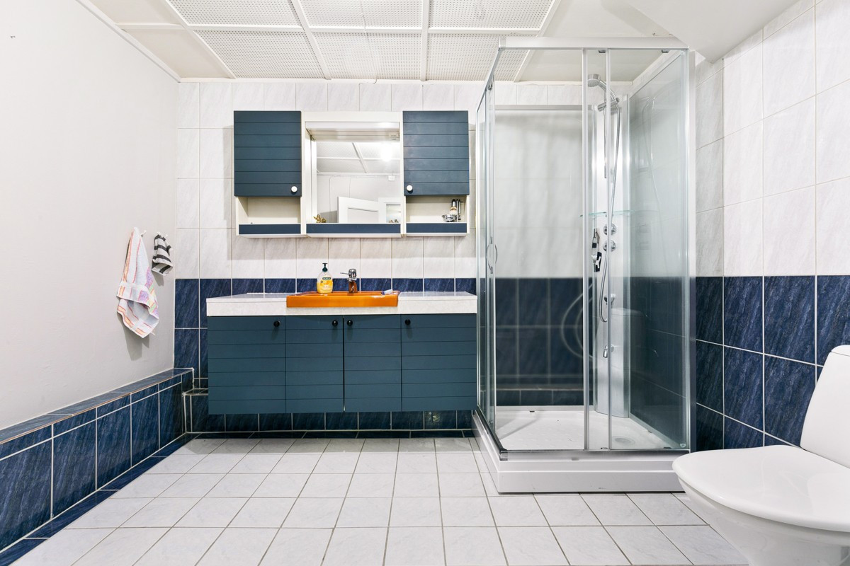 Badet i 0.etasje er utstyrt med dusjkabinett. Her er det flislagt gulv med gulvvarme