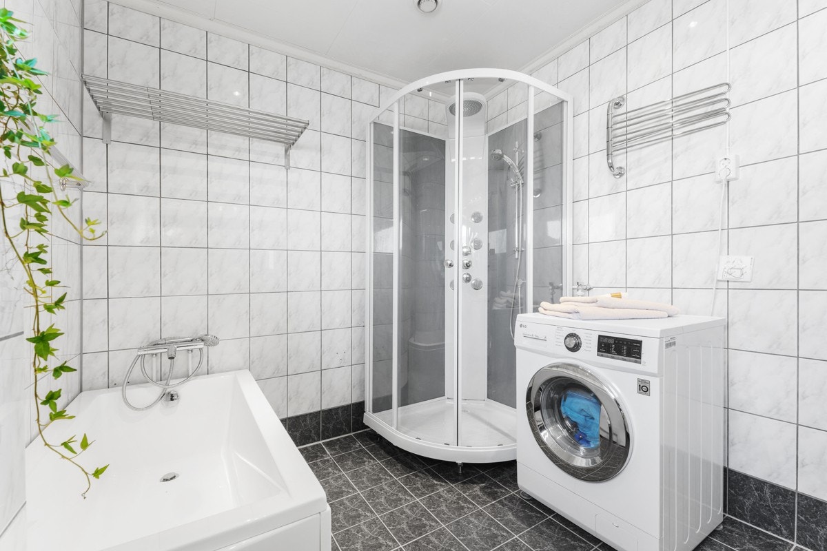 Av innhold finner vi vegghengt toalett, badekar, dusjkabinett, møblement med servant og opplegg for vaskemaskin. Galleribilde