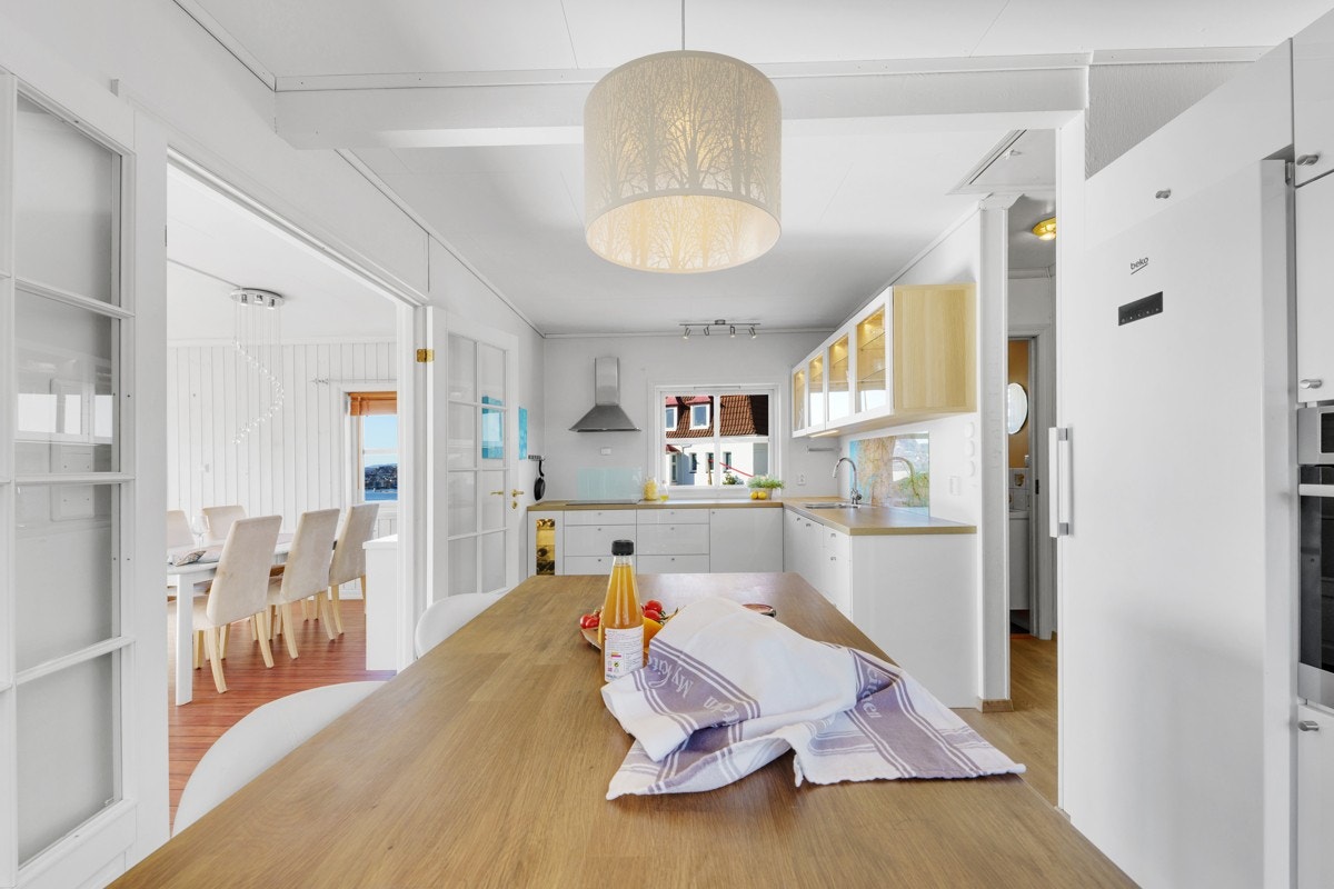 Gjennom doble glassdører ligger boligens kjøkken. Galleribilde