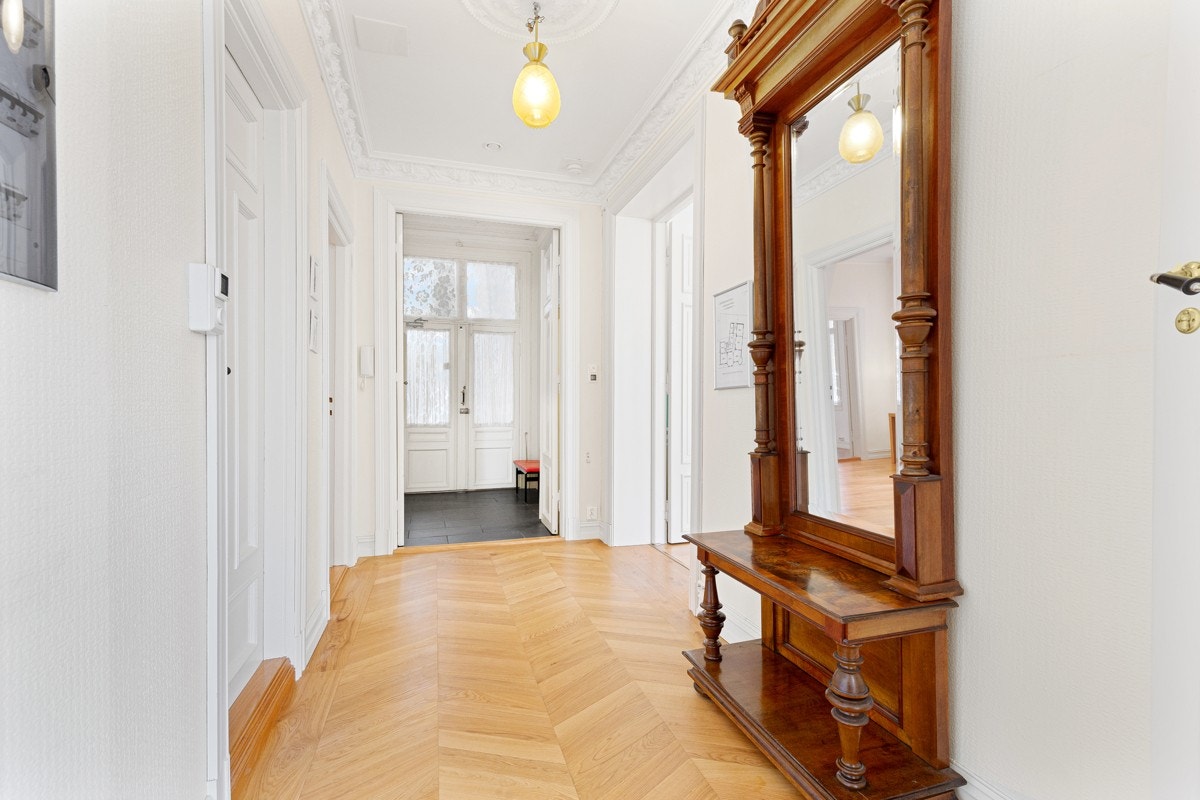 En tofløyet dør med glassfelt tar deg inn i denne flotte leiligheten. Entreen har fliser, hallen innenfor har parkett. Galleribilde