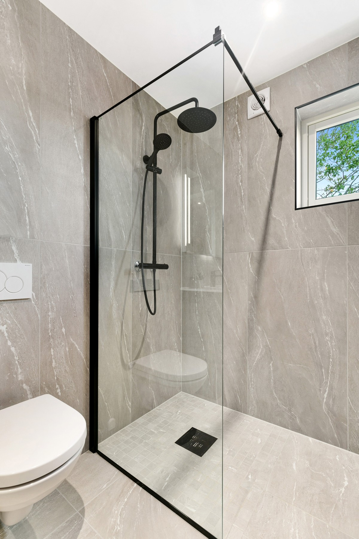 Badet er utstyrt med dusjnisje med glassvegg